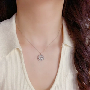 Close-up of sparkling snowflake necklace with white pearls and zircon stones on neck