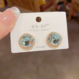 Détail macro de boucles d'oreilles carrées en zircon bleu clair avec tiges en argent S925