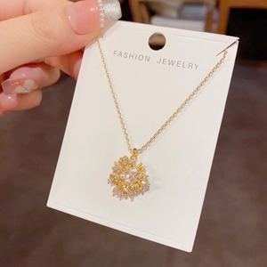 Macro view of golden firework pendant necklace with pearls and sparkling zircons