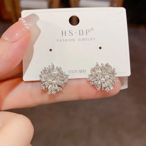 Detailed close-up of sparkling flower-shaped stud earrings with pearls and S925 silver needles
