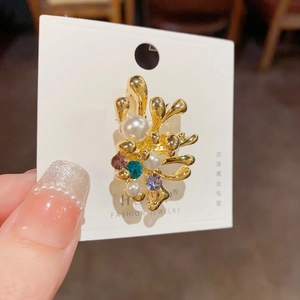 Détail de la bague corail dorée avec perles précieuses et strass en cristal multicolore