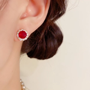 Détail de la boucle d'oreille halo avec pierre rouge et accents de zircon blanc