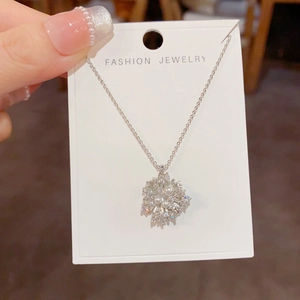 Detail of fireworks necklace pendant featuring micro-set rhinestones and elegant pearls