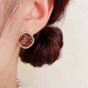 Gros plan détaillé d'une boucle d'oreille carrée en zircon violet avec halo de diamants