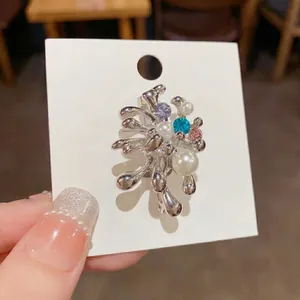 Broche en métal argenté motif feu d'artifice avec perles et cristaux colorés