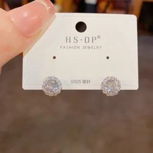 Détail de boucles d'oreilles tournesol en argent S925 avec zircons à la main