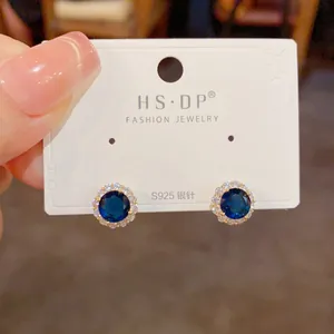 Détail de boucles d'oreilles en argent S925 avec zircon bleu et placage d'or