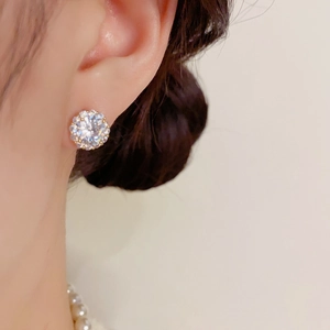 Gros plan de boucles d'oreilles halo rondes en zircon portées par un mannequin chic
