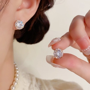 Gros plan de boucles d'oreilles halo minimalistes avec zircon et monture dorée