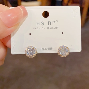 Gros plan de boucles d'oreilles halo en zircone cubique sur tiges en argent S925