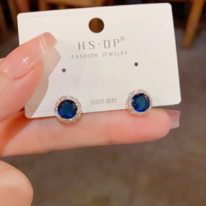 Gros plan de boucles d'oreilles saphir élégantes avec halo de zircon sur carte cadeau