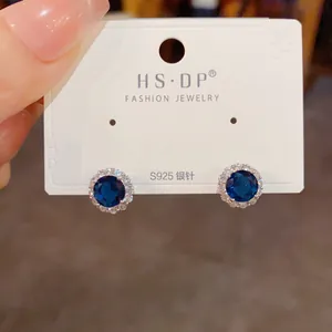 Détail de boucles d'oreilles en argent S925 avec pierre bleue et zircons blancs