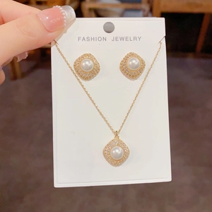 Detail view of gold rhonbus pearl jewelry set with micro-pave cubic zirconia accents