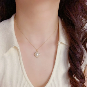 Elegant gold necklace set featuring a diamond-encrusted diamond-shaped pearl pendant detail