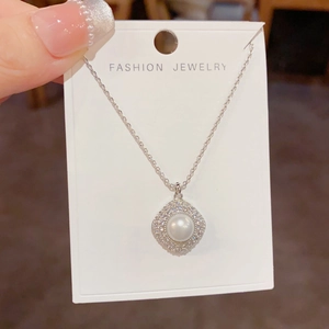 Detailed view of rhombic pendant with center pearl and micro-pave cubic zirconia crystals