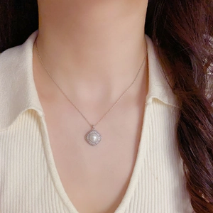 Close-up of rhodium-plated square pendant with pavé cubic zirconia and a center pearl