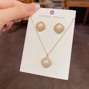 Close-up of gold-plated rhombus jewelry set with micro-pave zircons and white pearls
