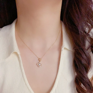 Elegant gold necklace with a micro-pave zircon four-leaf flower pendant on a model