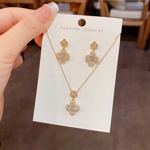 Detailed view of luxury gold clover jewelry set with sparkling white zircon inlay