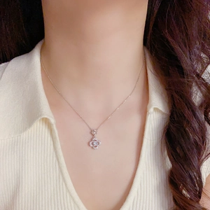 Macro view of silver four-leaf clover necklace with sparkling cubic zirconia on a model