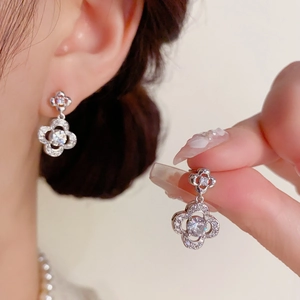 Close-up of sparkling silver clover earrings with micro-pave zirconia crystals