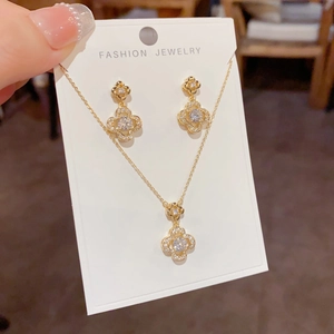 Macro view of gold four-leaf clover jewelry set with sparkling zircon micro-pave