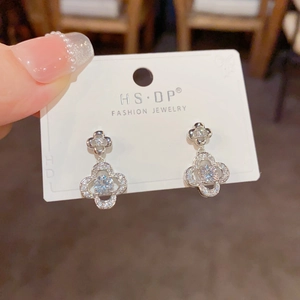 Macro detail of silver four-leaf clover earrings with micro-set sparkling cubic zirconia