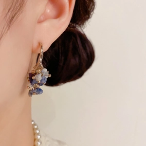 Close-up of elegant blue and white cluster grape bead drop earrings on model