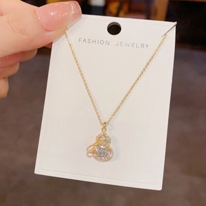 Makroaufnahme einer goldenen Flaschenkürbis-Halskette mit funkelnden Zirkonia-Steinen