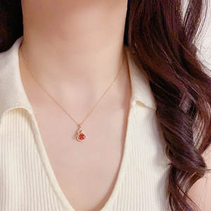 Nahaufnahme des goldenen Halsketten-Anhängers mit rotem Zirkon und Diamantbesatz