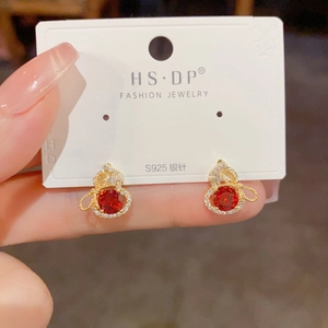 Gros plan sur les boucles d'oreilles gourde en argent S925 avec zircon rouge brillant