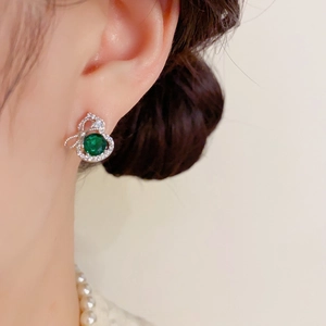 Boucles d'oreilles gourde vert émeraude élégantes avec zircons sur un mannequin