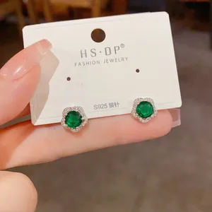 Gros plan de boucles d'oreilles en argent S925 avec zircon vert émeraude et fleurs