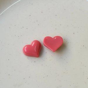 Macro-opname van glanzende roze hars hartjes voor DIY-sieraden en haaraccessoires