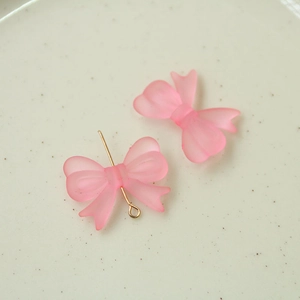 Detailansicht matter rosa Schleifenanhänger mit Goldstiften für DIY-Ohrringe