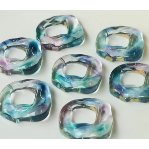 Macro detail of colorful translucent resin rings with marble ink pattern for DIY jewelry