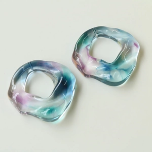Close-up of translucent colorful swirl resin rings with irregular hollow circle design
