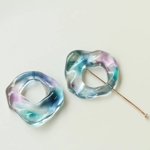 Close-up of translucent colorful marble resin rings and gold T-pin for DIY jewelry