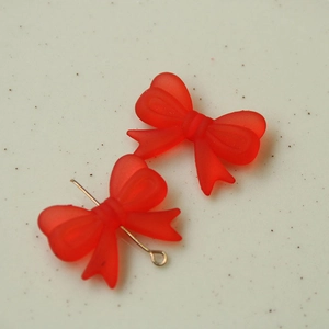 Makroaufnahme roter matter Acryl-Schleifenanhänger mit Metallstiften für DIY-Ohrring-Schmuck