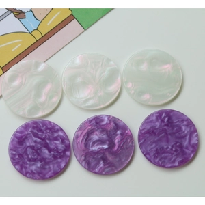 Macro shot of colorful acrylic round discs with pearl and marble texture for DIY jewelry