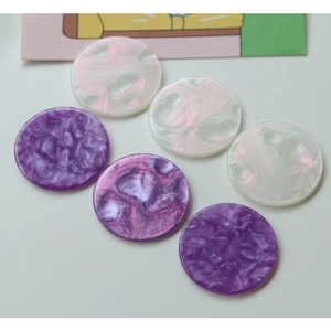 Macro detail of six iridescent acrylic marble round charms for DIY jewelry and accessories