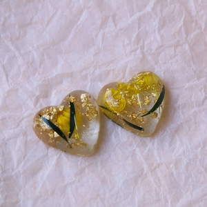 Detail of heart resin pendants with dried yellow flowers and gold foil accents