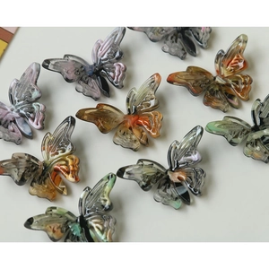 Macro detail of butterfly acetate resin charms with elegant marble patterns for DIY jewelry