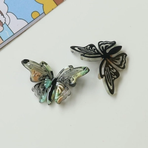 Detail of hollow butterfly acetate charms with marble texture for DIY hair accessories