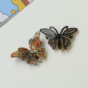 Acetate butterfly charm hair accessory in amber tortoise shell and black white patterns