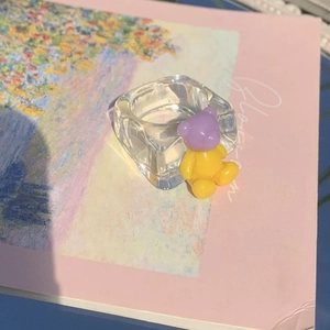 Detail view of transparent resin ring featuring a cute purple and yellow bear decoration