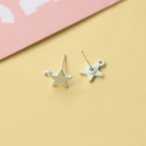 Dettaglio degli orecchini a stella con perni in argento S925 e finitura bianco opaco