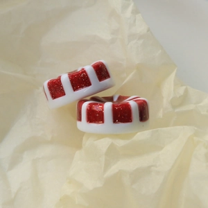 Makroaufnahme von rot-weißen Glitzer-Harz-Anhängern für DIY-Schmuck und Dekorationen