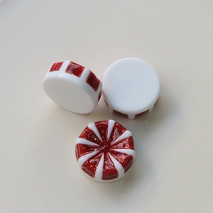 DIY-Bastelmaterial aus Harz mit rot-weißen Glitzermustern im Bonbon-Design
