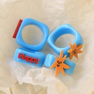 Blue acrylic ring set with Happy text and orange smiling starfish charms for women